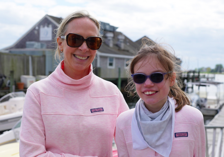 Mother and daughter smiling together at a marina before adaptive sailing