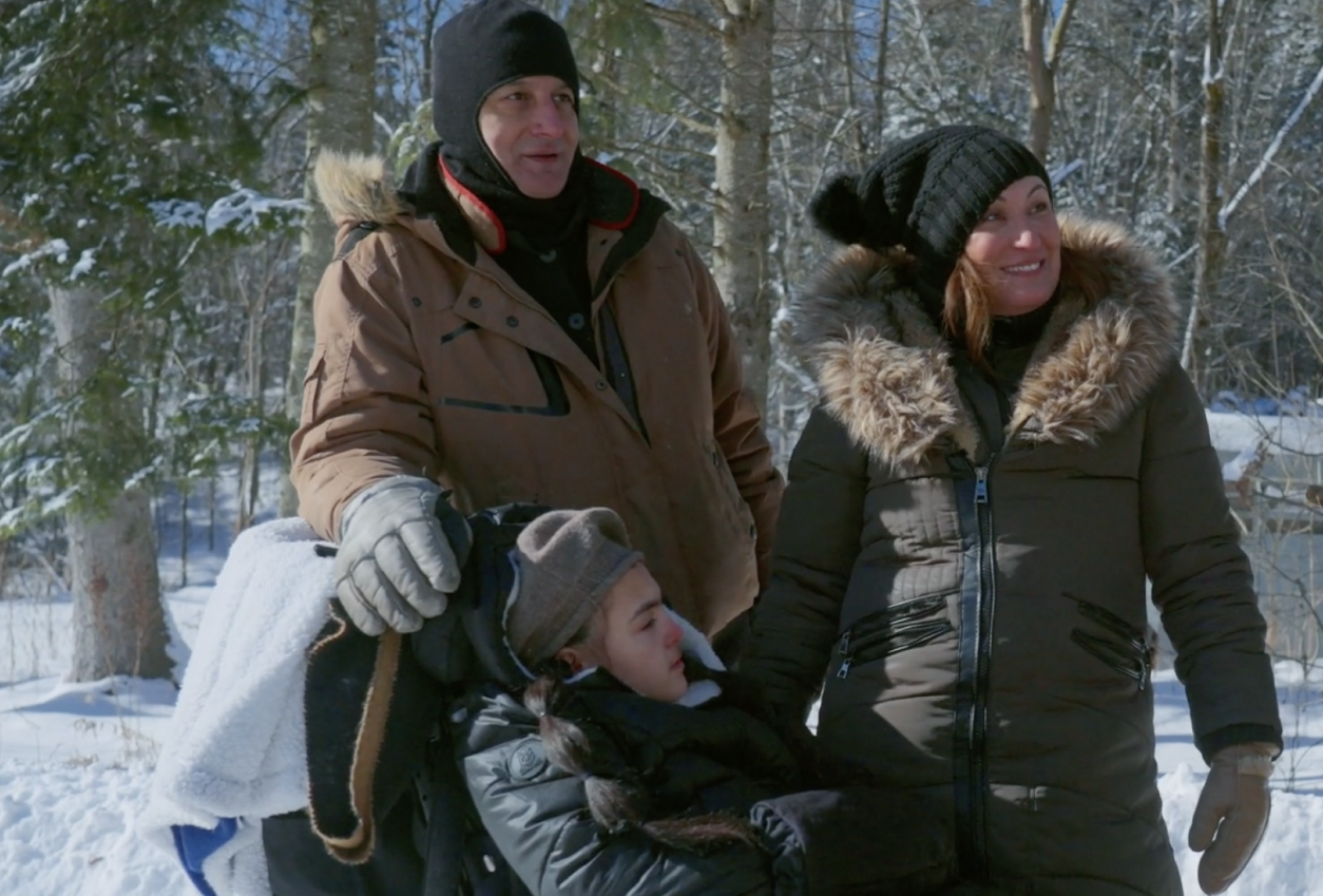 Family in the snow during adaptive dog sled before the ride