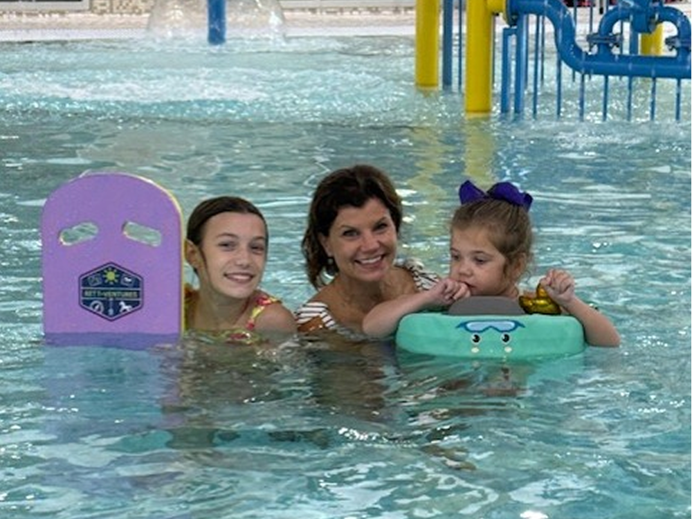 Child with Rett syndrome participates in a supported swimming activity