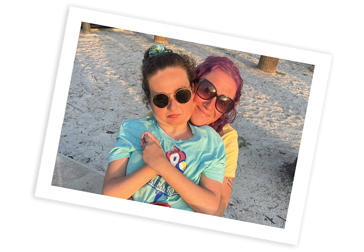 Caregiver hugs a child with Rett syndrome outdoors