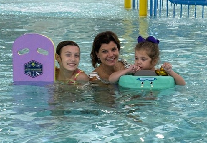 Child with Rett syndrome receives support during a swimming activity