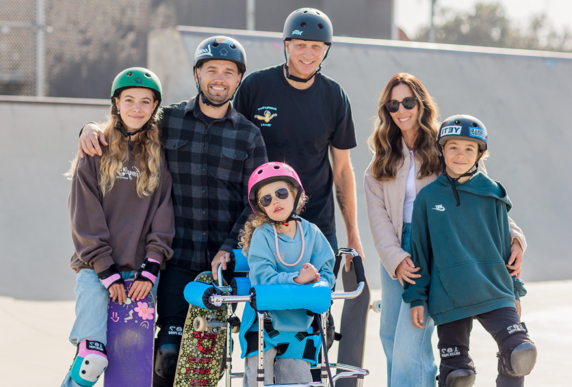 Family wearing helmets gathered at an adaptive skate park