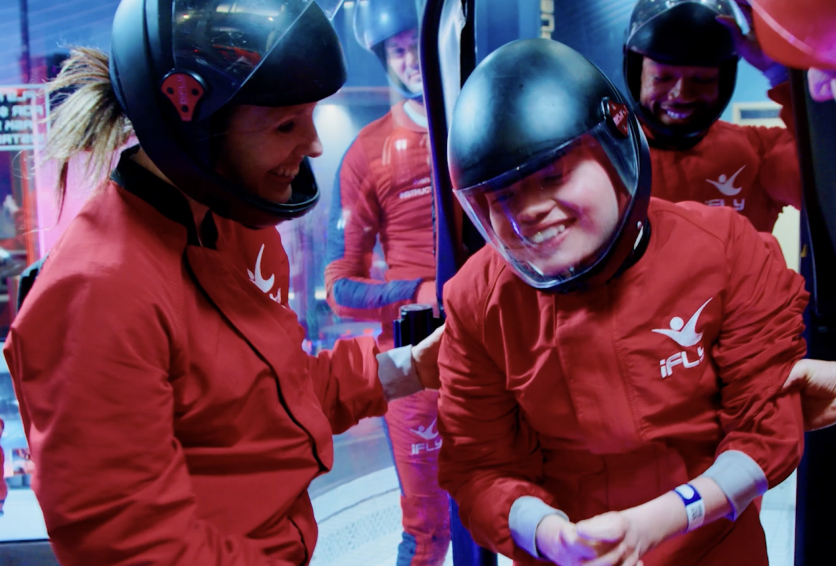 Child living with Rett syndrome smiles during indoor skydiving